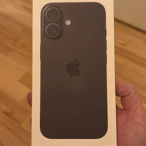 iPhone 16, 128GB, Black oöppnad  - Ny iPhone 16 i svart färg med 128GB lagring. Levereras i originalförpackning med USB-C laddningskabel. Modern design med dubbla kameror och hög prestanda. Kartongen är i fint skick utan synliga skador eller slitage. Perfekt för dig som vill ha den senaste tekniken.