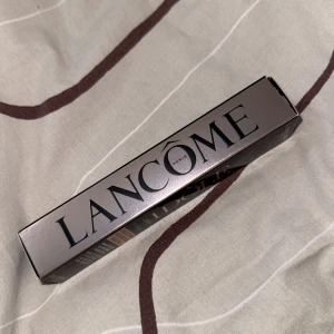 Lancôme Lash Idôle Waterproof Mascara - Säljer en Lancôme Lash Idôle Waterproof Mascara i färgen 01 Glossy Black. Volymgivande och lyftande formula som ger intensivt svarta och glansiga fransar. Kommer i en snygg svart och metallic-färgad förpackning med 8 ml produkt.