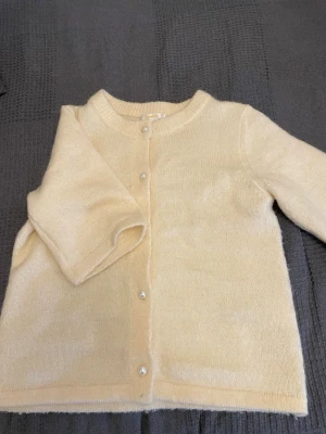 Gul stickad kofta från Gina Tricot - Mysig beige stickad kofta från Gina Tricot i storlek 158/164. Koftan har rund hals, korta ärmar och pärlknappar framtill som ger en extra touch. Nästan oanvänd. Pris kan diskuteras ❤️