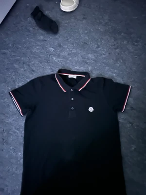 Svart Moncler piké  - Den är i bra skick och är äkta pris kan diskuteras