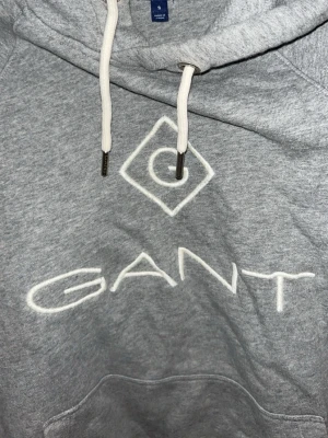 Grå hoodie från GANT - GANT hoodie från äldre kollektion i storlek S tröjan är väl omhändertagen och har inga tecken på användning eller slitage