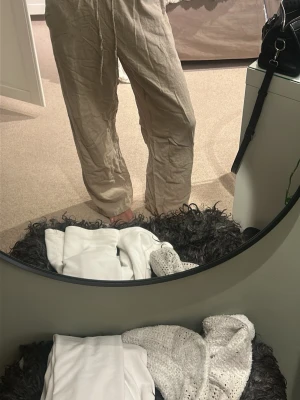 Beiga linnebyxor med snörning - Säljer ett par chill beiga linnebyxor med skön loose passform och snörning i midjan. Byxorna har raka ben och är perfekta för varma dagar. Materialet är linne som ger en avslappnad vibe och de är riktigt luftiga.