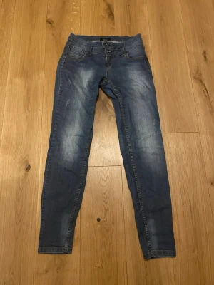 Pulz Skinny Jeans - Säljer ett par blå skinny jeans från Pulz Jeans i storlek 31. Jeansen har klassisk femficksdesign, snygga slitningar och kontrastsömmar. De är tillverkade i stretchigt denim för en bekväm passform och har en smal siluett som sitter tajt längs benen.