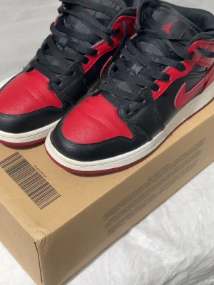 Jordan 1 "Banned" Mid - Jordan 1 "Banned" Mid i storlek 37,5. Använda men i fint skick. Finns lite märken och smuts på skorna men inte jätte smutsiga. Alltid använda med Anti Creaseskydd. Köpta på Merch Sweden för 1499kr. Säljs för 550kr 