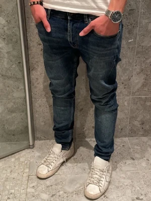 Tiger of sweden mörkblå jeans - Säljer ett par Tiger of sweden jeans i mörkblå tvätt med klassisk femficksdesign och smal passform. Jeansen har en snygg tapered siluett och är tillverkade i slitstarkt bomullsmaterial med lite stretch för extra komfort. Perfekt för dig som gillar en modern look. Pris kan diskuteras vid snabbaffär