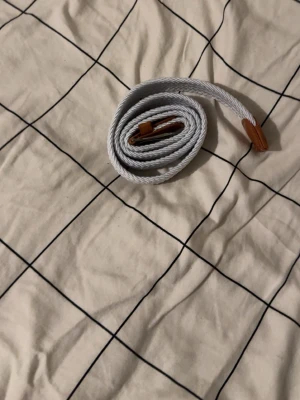 Vit flätat grisch bälte  - Detta bälte är bra för dig som vill va Grisch, det passar jätte bra och bältet är 102 cm lång. Den har användes 1-2 gånger 