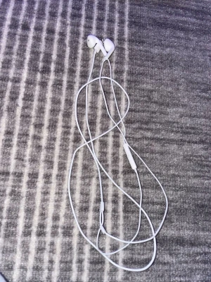 Apple EarPods kabelanslutna hörlurar - Snygga vita Apple EarPods med kabel och inbyggd mikrofon/fjärrkontroll. Passar perfekt för musik och samtal. Hörlurarna är i gott skick utan synliga defekter eller slitage. Klassisk design och bekväm passform. Finns i Göteborg att hämta!