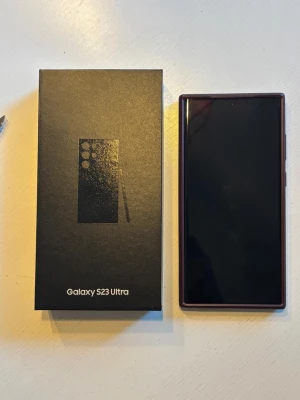 Samsung Galaxy S23 Ultra - 512 gb - Samsung Galaxy S23 Ultra i mycket fint skick, komplett med originalkartong och ett elegant brunt skal. Telefonen har flera avancerade kameror och stor skärm. Inga synliga repor eller skador, ser ut som ny. Perfekt för dig som vill ha topprestanda och snygg design.