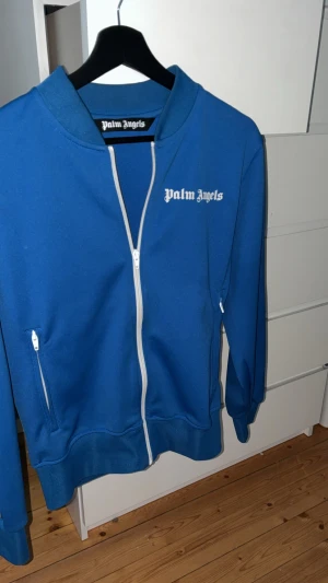 Blå zip hoodie från Palm Angels - Säljer en blå Palm Angels-tröja i mycket bra skick. Stilren och trendig, knappt använd. Hör av dig vid intresse!