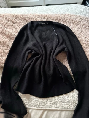 Svart stickad tröja från Bik Bok - Svart stickad tröja från Bik Bok i storlek M. Tröjan har en enkel rund halsringning och långa ärmar. Mjuk och skön kvalitet som passar perfekt till kyligare dagar. Stilren och lätt att matcha med olika outfits.