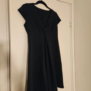 Egerie fransk klänning - Marinblå kortärmad klänning från Egerie med v-ringning och snygg knutdetalj framtill. Tillverkad i Frankrike. Klänningen har en lätt utställd form och är tillverkad i mjukt, stretchigt material med struktur. Säljer då den tyvärr är för stor för mig. Storlek T3, vilket motsvarar L