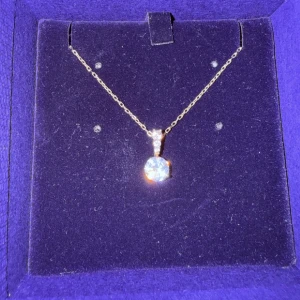 Swarovski guldhalsband med gnistrande sten - Elegant halsband från Swarovski med tunn guldfärgad kedja och en rund, glittrande klar sten som hänge. Perfekt för dig som gillar stilrena smycken med lite extra bling. Justerbar längd och diskret låsdetalj. Vid köp av två eller fler får du dessutom välja en present 🎁❤️ (presenterna kan jag visa i DM eftersom de inte finns upplagda här).