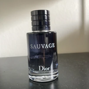 Dior Sauvage herrparfym - Stilren och populär herrparfym från Dior. Perfekt för dig som vill sticka ut med en modern och självsäker känsla. Snygg flaska som passar in i alla badrum. Den har hälften kvar.