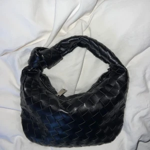 Svart axelväska från Bottega Veneta - Snygg svart axelväska inspirerad av Bottega Veneta i flätat material. Med tvinnad axelrem. Helt ny. 