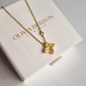 Guldigt halsband s925 - Superfint halsband i guld med en stjärnformad berlock dekorerad med små gnistrande stenar. Kedjan är tunn och elegant med en extra liten steninfattning. Perfekt detalj för att lyfta din look. Lådan ingår ej.