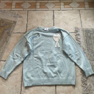 Ljusblå stickad tröja från Ami - Säljer en ljusblå stickad tröja från Ami som jag fick i present men passade inte. Den är aldrig använd. Pris kan diskuteras!