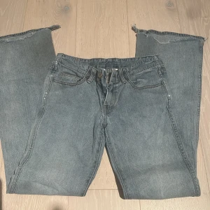 Brandy lågmidjade jeans - Säljer ett par bootcut brandy melville jeans, ljusblåa/gråisha. Super trendiga och snygga men tyvärr lite sönder och jag kan inte sy … men passae super fint. Dom är perfekt längd och jag är 171! 