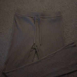 Beige ribbade mjukisbyxor med snörning - Säljer ett par beige ribbade mjukisbyxor med snörning i midjan. Byxorna har en relaxed passform och är perfekta för chill dagar. Materialet är mjukt och stretchigt