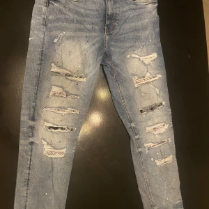 Supply & Demand ljusblå ripped jeans - Ljusblå jeans från Supply & Demand med slitna detaljer och färgstänk. Skinny fit med flera revor framtill och klassiska bakfickor. Perfekta för dig som gillar en edgy streetstil. Materialet är klassisk denim.