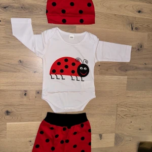 Röda prickiga barnbyxor med svart midja nyckelpiga 🐞  - Söta röda barnbyxor med svarta prickar och svart midja. Byxorna är mjuka och bekväma, perfekta för lek och bus. Matchar med body och mössa i nyckelpigemotiv för en gullig look.🥰