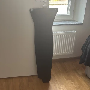 Svart ribbad lång klänning från New yorker - Svart lång klänning från New yorker i ribbat material. Kjolen har en tight passform och en snygg slits framtill som ger extra edge. Perfekt för dig som gillar minimalistisk och stilren look den är andvänd 2 gånger.