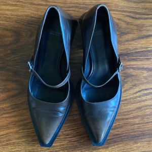 Bruna KlackskorVagabond - Snygga bruna Mary Jane-skor från Vagabond i skinn med markerad spetsig tå och bred klack. Skorna har en smal rem med silverfärgat spänne över foten och en cool, modern siluett. Perfekta för dig som gillar en edgy men klassisk look. De är i fint skick, lite repor vid hälen annars fint. Använda några fåtal gånger. Storlek 38, men smala och lite mindre i storleken. Säljer för 400 kr + frakt (köpare står för frakten) 💕