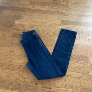 Mörkblå skinny jeans från Denim - Mörkblå jeans från Denim i storlek XS med skinny passform. Byxorna har en klassisk design med dragkedja i sidan och knapp i midjan. Perfekta för dig som gillar en tajt och stilren look.