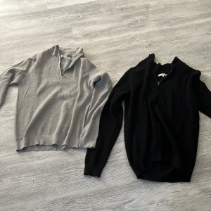 2 stickade half zip-tröjor från S.C.W - Två stickade tröjor från S.C.W i storlek L, en svart och en ljusgrå. Båda har half zip-dragkedja och ribbad struktur. Perfekt för lager-på-lager och chill stil. Långärmade och med klassisk passform.