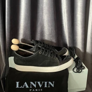 Svarta sneakers från Lanvin - Snygga svarta sneakers från Lanvin med vit sula och svarta skosnören. Kommer med originalpåse, orginalboxen och extra skosnören. Nypris på dessa är runt 4500kr. Säljs här för 1999kr och är i nästan helt nytt skick, pris kan diskuteras.