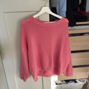 Rosa stickad tröja med loose fit - Supermjuk rosa stickad tröja med avslappnad, loose passform och rund halsringning. Perfekt för lager-på-lager och ger en chill vibe till din outfit. Långa ärmar och ribbade muddar för extra komfort.