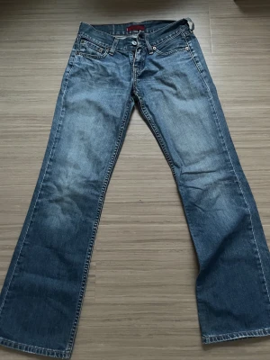 Levi's Eve square  cut straight - Blå jeans från Levi's modell Eve med straight cut och klassisk femficksdesign. Snygga kontrastsömmar och ikonisk Levi's-lapp bak i midjan. Jeansen har normal passform och är tillverkade i slitstarkt denimtyg. Perfekt för dig som gillar tidlös stil och bekväma jeans.