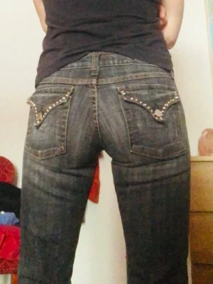 Flying Monkey jeans med nitar, stl 5 - Gråsvarta jeans från Flying Monkey med snygga nitar runt bak- och framfickor.. Jeansen är lågmidjade och bootcut. 