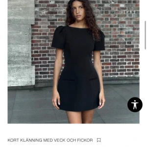 Svart kort klänning med fickor och puffärm - Helt ny. Prislapp sitter kvar 