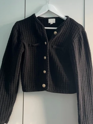 Svart stickad kofta - Snygg svart stickad kofta med guldfärgade knappar framtill❤️