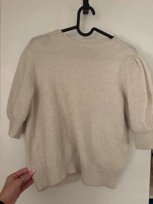 Beige stickad tröja från Vero Moda🫶🏻 - Supermysig beige stickad tröja från Vero Moda med korta puffärmar och ribbade muddar. Perfekt för lager-på-lager och funkar lika bra till jeans som kjol. Enkel och stilren design som är lätt att matcha🤍