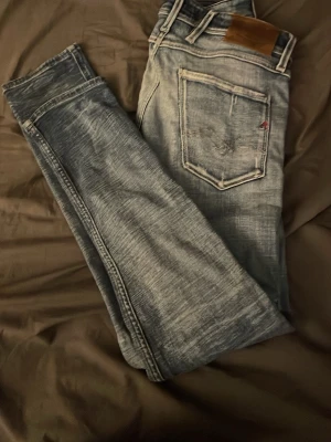 Replay Anbass jeans  - Tjenare, jag säljer dessa snygga Replay Anbass jeans med slitningar, byxorna är i ett gott skick, hör av er vid frågor och liknande, priset är ej hugget i sten ba släng iväg ett bud.