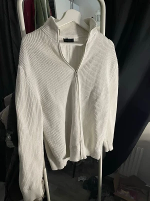 Vit Kofta - Vit stilren kofta från ”SMOG”. Riktigt skön lätt att matcha med, storlek S men sitter mer som en M. Säljes för att den är för stor för mig.