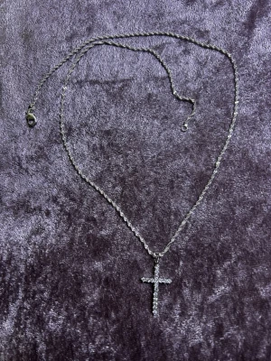 925 Silverpläterad ( stämplad) Strass korshalsband - Säljer ett stilrent halsband i Silverpläterad med ett korsformat hänge som är dekorerat med glittrande stenar. Kedjan har en tvinnad design och ett smidigt lås. Perfekt för dig som gillar detaljer med lite extra bling. Helt ny 