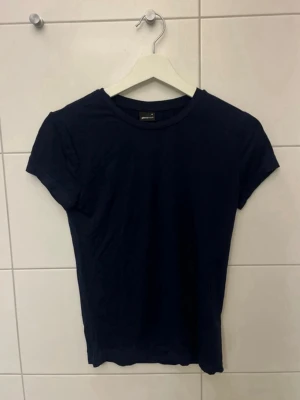 Mörkblå t-shirt från Gina Tricot - använd en gång. tight t-shirt från gina tricot. stretchigt material som sätter sig slimmat mot kroppen💓