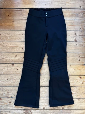 Svarta skidbyxor från 8848 Altitude storlek 160/ XXS - Säljer ett par svarta skidbyxor från 8848 Altitude i klassisk slalomodell. Förstärkta över knäna. Byxorna har, två knappar i midjan och är tillverkade i ett slitstark polyamid. Perfekt skick! Storlek 160/ XXS