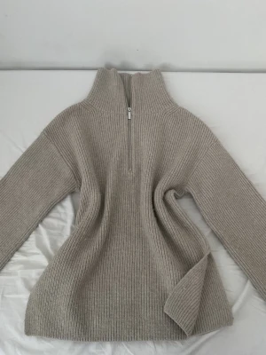Beige stickad tröja half zip från H&M - Säljer en beige stickad tröja från H&M i storlek XS. Den är i jätte bra skick då jag haft på mig den bara två gånger. Mycket skön, varm och sticks inte, perfekt till vinter, våren och höst. Tröjan har en hög krage och en snygg half zip-dragkedja framtill. Ribbad struktur och långärmad modell som ger en chill och stilren vibe. Perfekt för lager-på-lager under kyliga dagar.