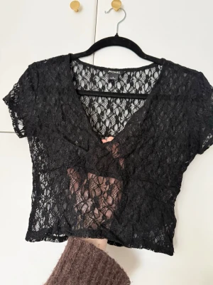 Svart spetstopp  - Svart spelstopp från Monki med v-ringning. Använd fåtal gånger, inga skavanker eller så. Hör gärna av er om ni har några funderingar! Säljer även en likadan i vit!