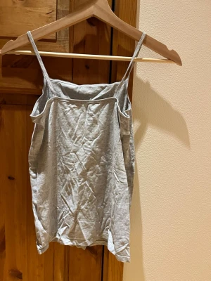 Linne - Enkelt grått linne från H&M i storlek 158/164. Väl använd men i bra skick. Djur och rökfritt hem.