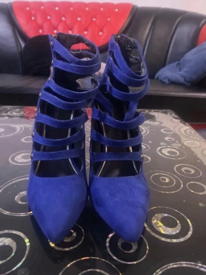 Royal Blue Suede Cut-Out Ankle Boots – High Heel Stilettos - Stylish royal blue ankle boots in soft suede-look material with multiple cut-out straps and a slim stiletto heel. Very eye-catching and perfect for parties, nights out, or special occasions. • Elegant pointed toe • High stiletto heel • Cut-out strap design • Zip closure at the back • Color: Royal/Cobalt Blue Condition: Very good condition, worn only a few times. Minor signs of wear on the sole only (see photos).  Selling because I don’t use them. 
