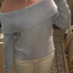 Ljusblå offshoulder stickad tröja H&M - Superfin ljusblå stickad tröja från H&M med bred offshoulder-ringning. Mjuk och mysig känsla, perfekt för kyliga dagar. Långärmad och ribbade muddar vid ärmslut och nederkant. Snygg att styla med jeans eller kjol.