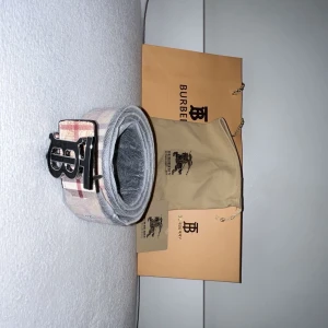 Burberrybälte  - Kommer med låda och påse för att inte smutsa ner sig. Svart logo och rutigt bälte 