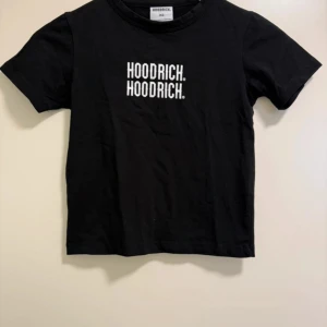 Svart t-shirt från Hoodrich - Svart t-shirt från Hoodrich med vit logga tryckt två gånger. Den är knappast använd och i nyskick. Säljer den då jag inte fått någon användning för den.