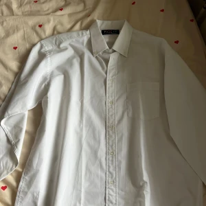 Vit skjorta från Polo L.O - Vit damskjorta från POLO Hollywood Country Club. Använd endast en gång och är i jätte bra skick. Storlek L men passar även jätte fint för er som har  storlek M!