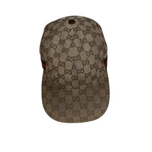 Gucci keps med GG-mönster och läderrem - Snygg beige keps från Gucci med klassiskt GG-monogram över hela ytan. Kepsen har en justerbar rem i brunt läder baktill och detaljer med gröna och röda ränder på sidan. Tillverkad i bomullsmaterial med exklusiv känsla, perfekt för dig som gillar designeraccessoarer. 