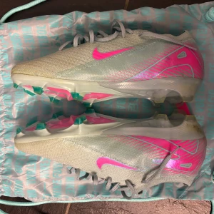 Nike fotbollsskor ljusblå/rosa - Säljer ett par fotbollsskor nästan helt nya och säljer då jag har slutat spela. Det är elite versionen och originalpåse följer med. Köpta för nån vecka sedan för 2600kr på unisport.